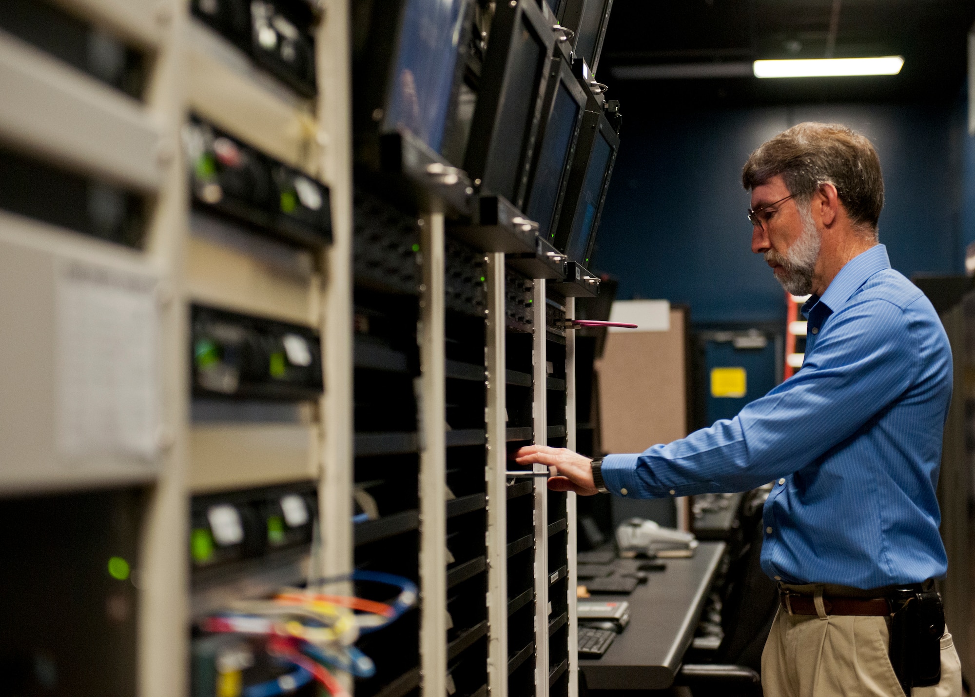 Mark Lapre, 96th Range Control Squadron, places a new disc in one of a bank of DVD players to record the communications during a test from the central control facility at Eglin Air Force Base, Fla., April 6.  The 96th RCS through its CCF provides real-time mission control of airborne test and large force training missions on the Eglin Test and Training Range. The CCF is a state-of-the-art facility analogous to NASA’s mission control but on a smaller scale. Operations involve the real-time tracking and control of aircraft and weapons in flight, data collection, and data processing for real-time and post-mission system under test performance analysis.(U.S. Air Force photo/Samuel King Jr.)