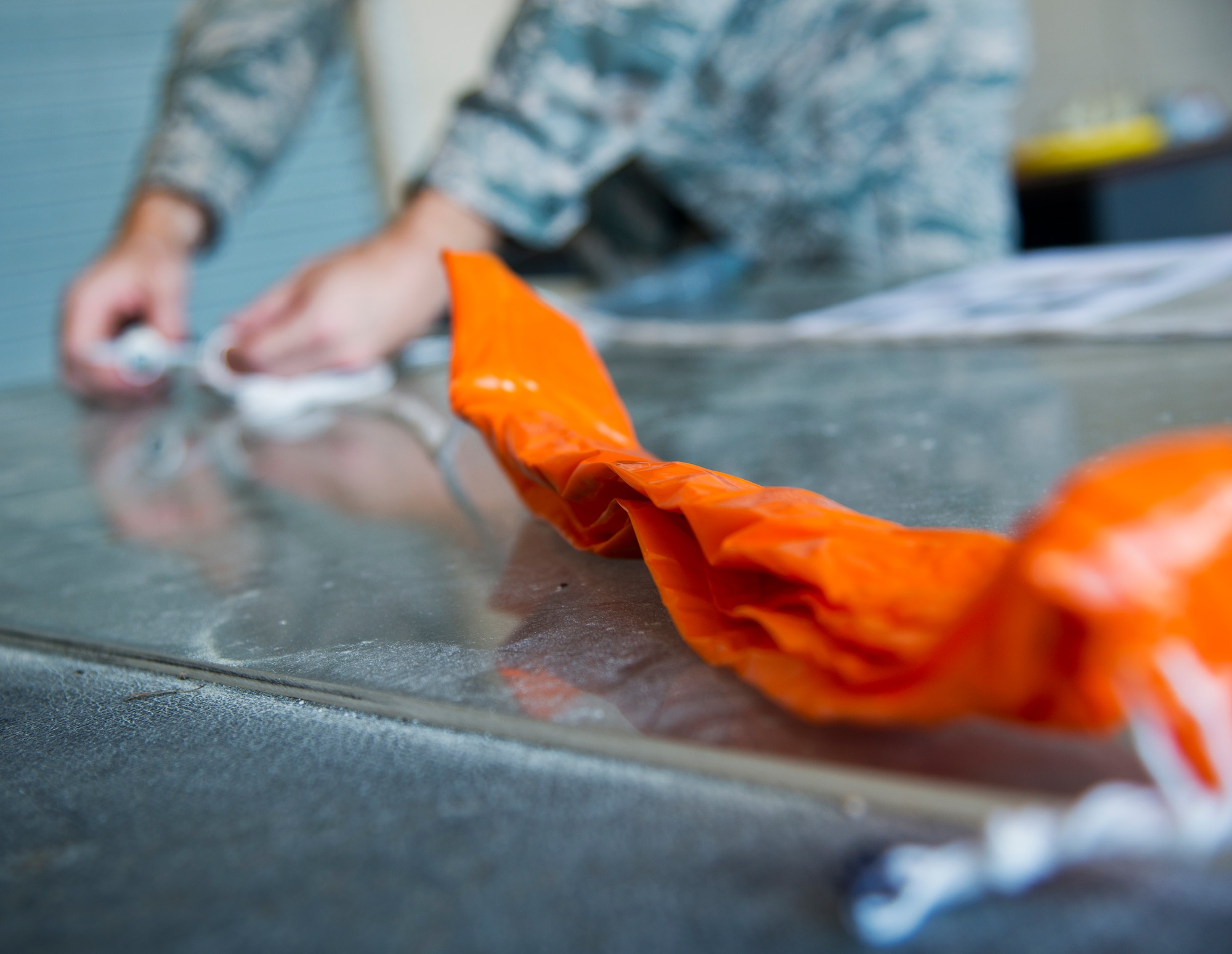 Tech. Sgt. Nathan Halvorson, 96th Weather Flight, secures a tag to the end of an orange parachute on a weather balloon prior to a launch from Eglin Air Force Base, Fla.  (U.S. Air Force photo/Samuel King Jr.)