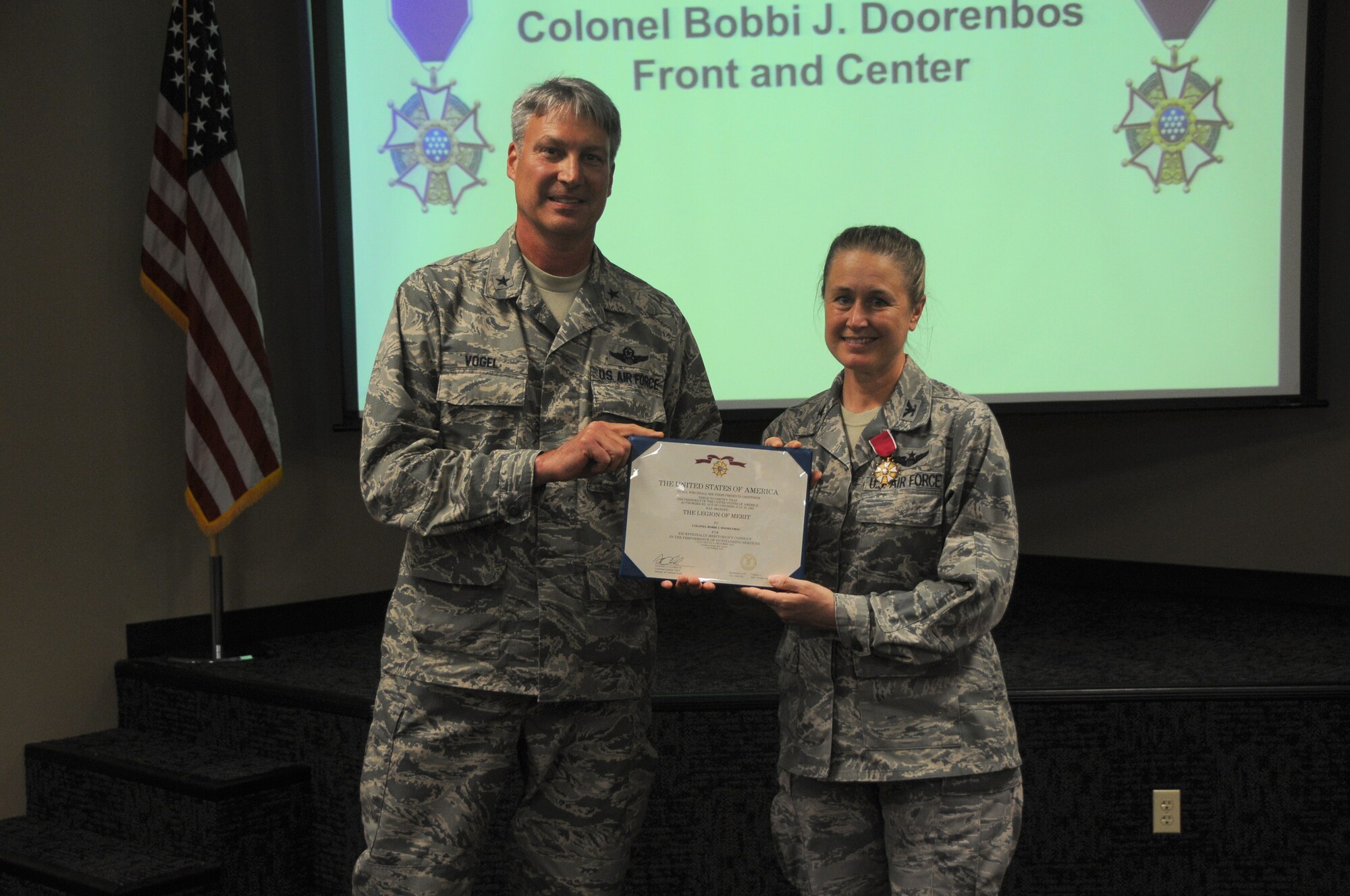 Brig. Gen. Kurt Vogel, Arkansas Air National Guard commander, presents Col. Bobbi Doorenbos, 188th Wing commander, with the Legion of Merit June 7, 2015 at Ebbing Air National Guard Base, Fort Smith, Ark. The award is to recognize Doorenbos for her achievements as the 214th Reconnaissance Group commander for the 162nd Wing in Arizona. (U.S. Air National Guard photo by Senior Airman Cody Martin/Released)