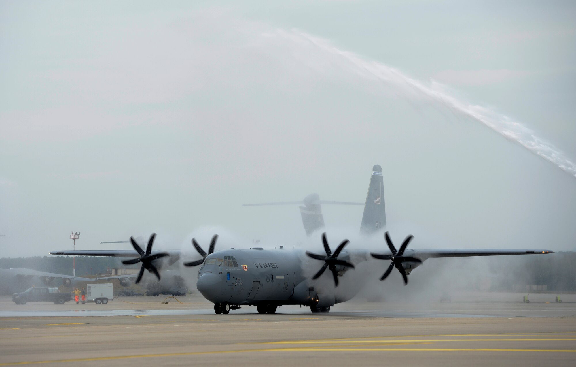 Brig. Gen. Patrick X. Mordente taxis a C-130J Super Hercules as the aircraft gets sprayed down by firetrucks on June 10, 2015, Ramstein Air Base, Germany. Mordente, along with several aircrew members from the 37th Airlift Squadron, took his 4-hr final flight over Germany on the anniversary of his pilot training graduation date 27 years ago. (U.S. Air Force photo/1st Lt. Clay Lancaster)