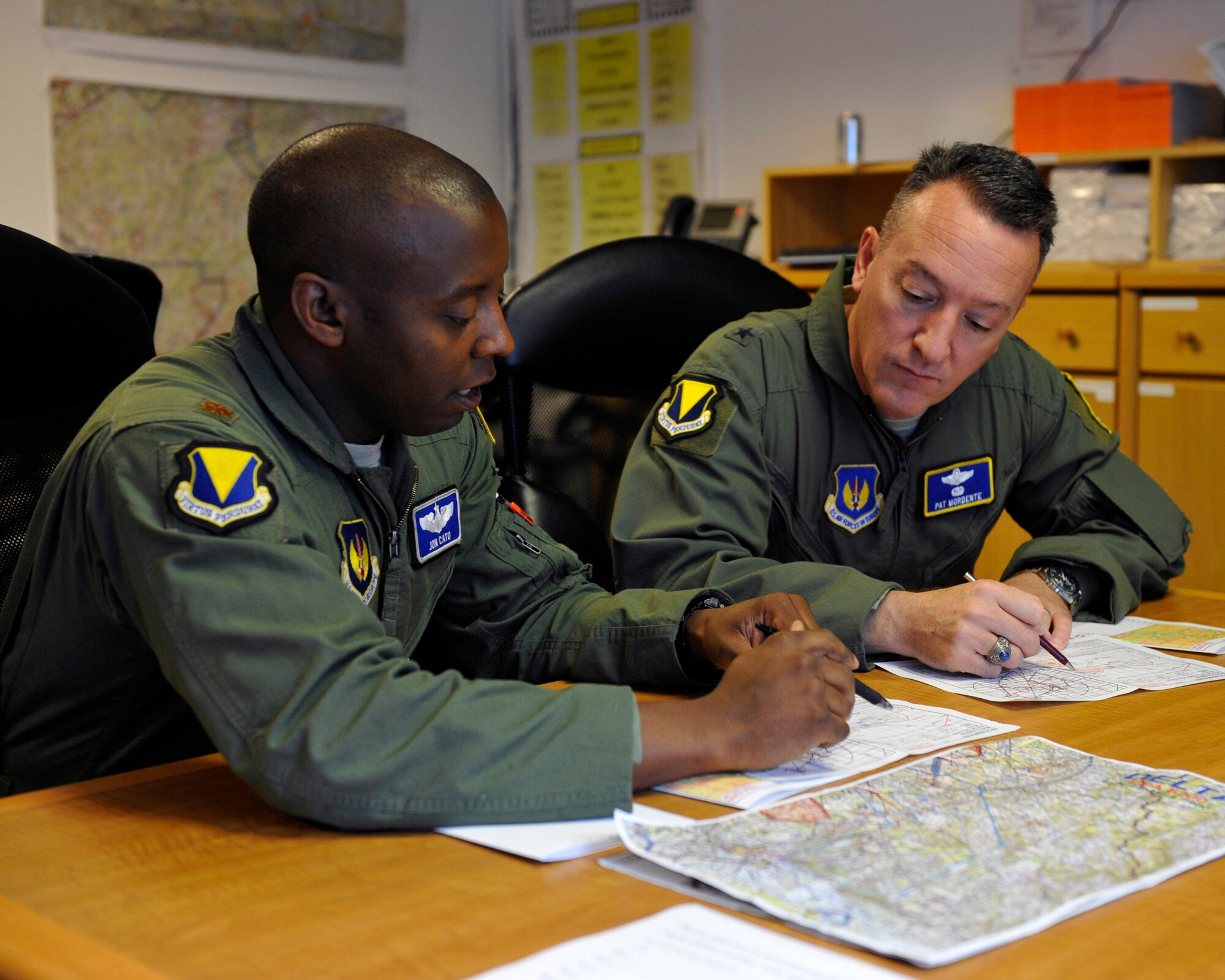 Brig. Gen. Patrick X. Mordente, 86th Airlift Wing commander, receives a mission brief from Maj. Jonathan Cato, 37th Airlift Squadron C-130J Super Hercules pilot, prior to his final flight on June 10, 2015 at Ramstein Air Base, Germany. Mordente’s flight signified his last flight as the commander of the wing and with the 37th AS. (U.S. Air Force photo/Staff Sgt. Leslie Keopka)  