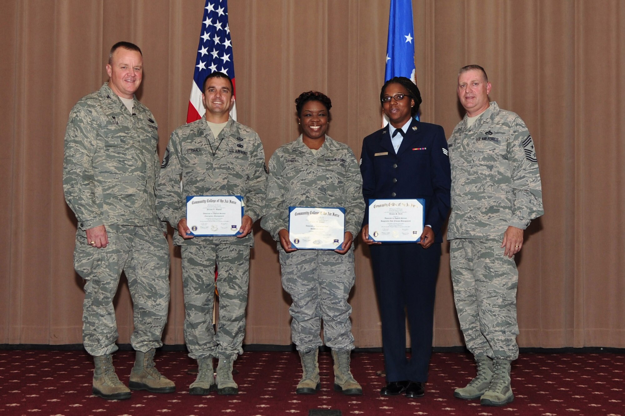 U.S. Air Force Col. Bruce Cox, 307th Bomb Wing commander (left) and Command Chief Master Sgt. Randy Noble (far right), stand with Community College of the Air Force degree recipients Master Sgt. Jeremy Utphall, 307th Bomb Wing, Tech. Sgt. Angela Daniel, 307th Bomb Wing, and Senior Airman Alyssia Reed, 307th Force Support Squadron, June 7, 2015, Barksdale Air Force Base, La.  (U.S. Air Force photo by Master Sgt. Laura Siebert/Released)