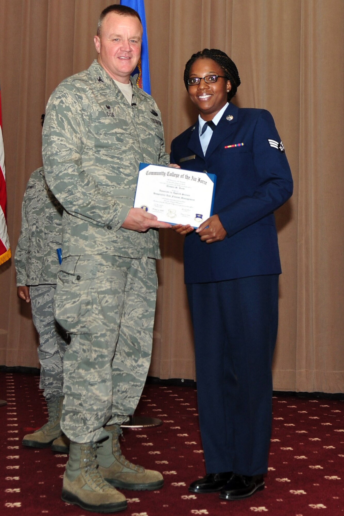 U.S. Air Force Col. Bruce Cox, 307th Bomb Wing commander, presents Senior Airman Alyssia Reed, 307th Force Support Squadron, her degree from the Community College of the Air Force in Hospitality & Fitness Management, June 7, 2015, Barksdale Air Force Base, La.  (U.S. Air Force photo by Master Sgt. Laura Siebert/Released)
