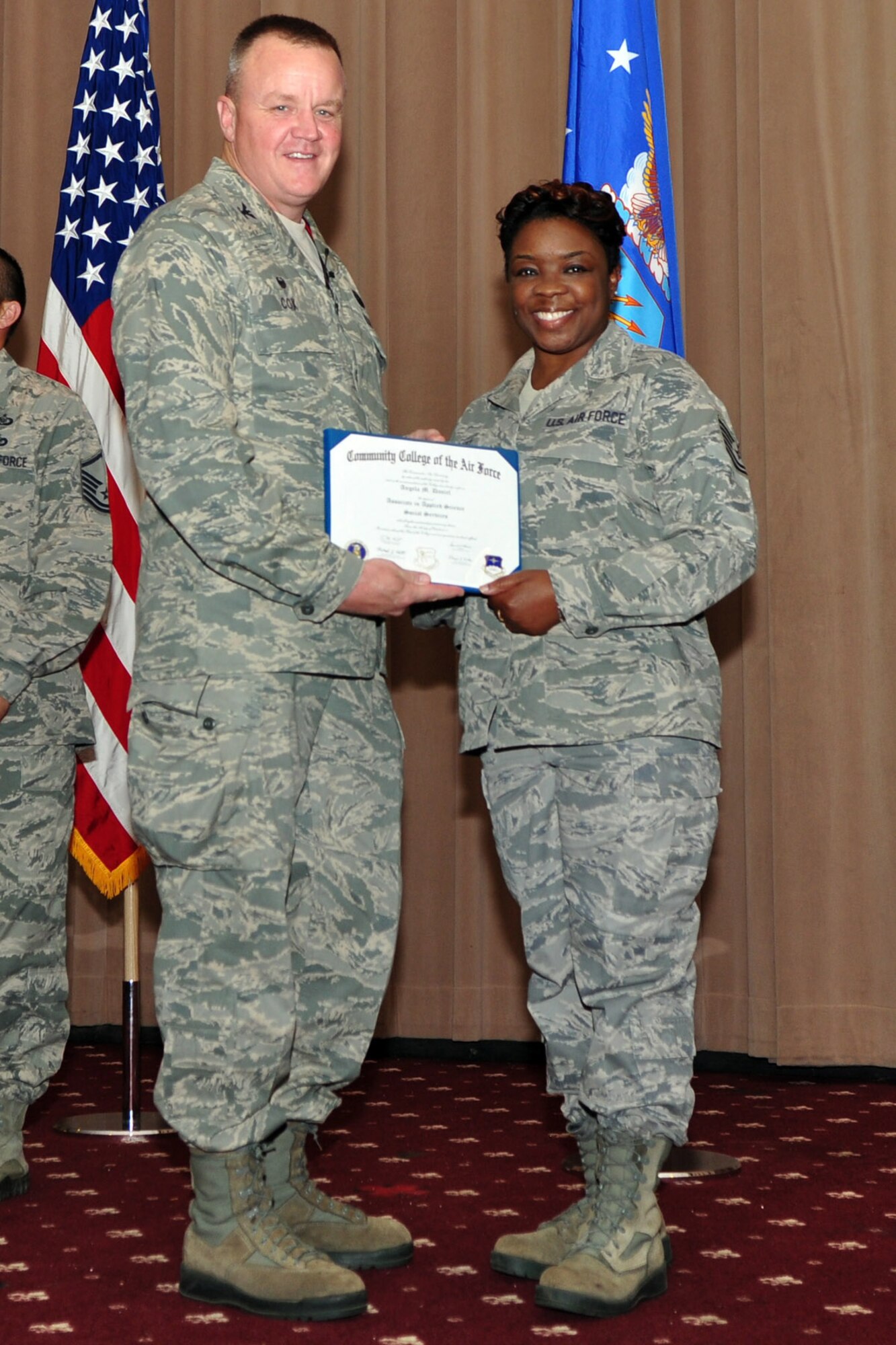U.S. Air Force Col. Bruce Cox, 307th Bomb Wing commander, presents Tech. Sgt. Angela Daniel, 307th Bomb Wing, her degree from the Community College of the Air Force in Applied Science Social Services, June 7, 2015, Barksdale Air Force Base, La.  (U.S. Air Force photo by Master Sgt. Laura Siebert/Released)