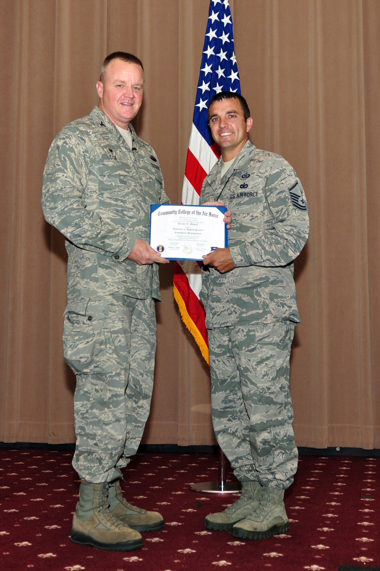 U.S. Air Force Col. Bruce Cox, 307th Bomb Wing commander, presents Master Sgt.  Jeremy Utphall, 307th Bomb Wing, his degree from the Community College of the Air Force in Applied Science Emergency Management, June 7, 2015, Barksdale Air Force Base, La.  (U.S. Air Force photo by Master Sgt. Laura Siebert/Released)