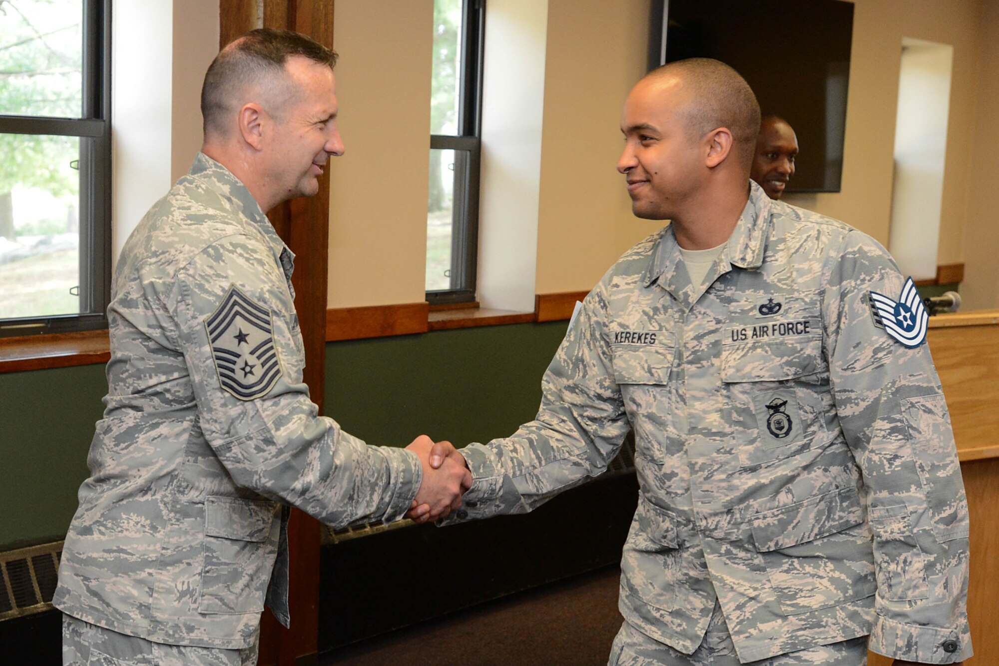 Hanscom Command Chief Master Sgt. Craig A. Poling congratulates Staff Sgt. Anthony J. Kerekes, 66th Security Forces Squadron resource advisor, on being selected for promotion to technical sergeant during a recognition ceremony at the Minuteman Commons June 9. Kerekes and 12 other Airmen assigned to Hanscom were selected for promotion to technical sergeant. (U.S. Air Force photo by Jerry Saslav)