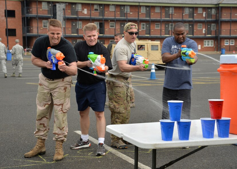 From left, U.S. Air Force Colonels David Cox, 100th Air Refueling Wing vice commander; Thomas D. Torkelson, 100th ARW commander; Nathan Green, 752nd Special Operations Group commander, and Earl Scott, 100th Maintenance Group commander, fire water guns as they try and knock down plastic cups as part of the Chiefs vs. Eagles vs. Airmen Defender Challenge at the Unaccompanied Airmen’s Appreciation Day event June 5, 2015, on RAF Mildenhall, England. The event was held to build morale of Airmen stationed here without families, and provided an opportunity for them to get together with base leadership and have fun. (U.S. Air Force photo by Karen Abeyasekere/Released)