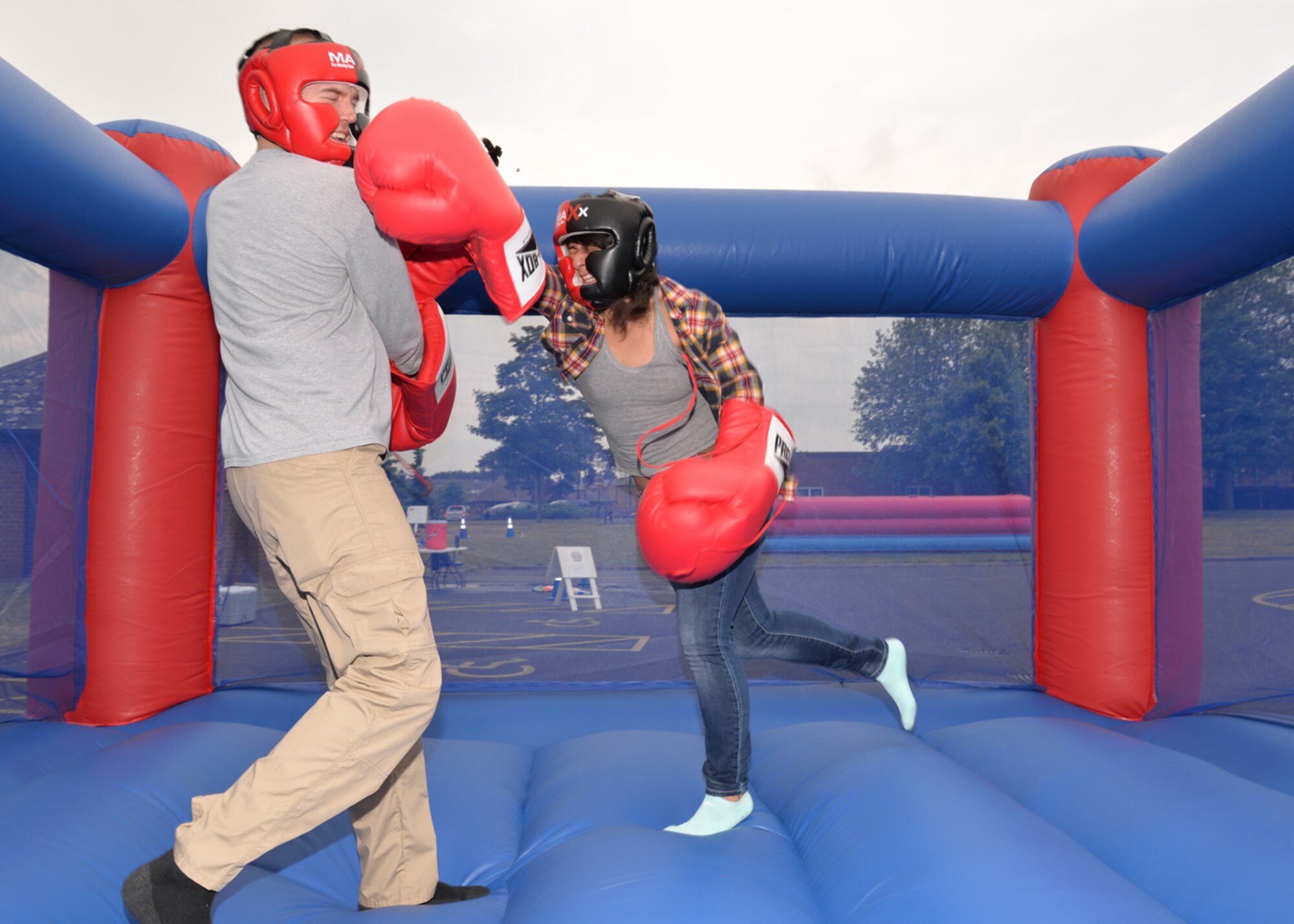 U.S. Air Force Airman 1st Class Amanda Rochin, right, 100th Operations Support Squadron airfield systems technician from San Diego, throws a punch at U.S. Air Force Airman 1st Class Ian Radandt, 100th OSS aircrew flight equipment technician from OshKosh, Wis., as they take a turn on the inflatable boxing ring at the Unaccompanied Airmen’s Appreciation Day event June 5, 2015, on RAF Mildenhall, England. Single Airmen of all ranks participated in a variety of activities including a wall climb, dunk tank, and Chiefs vs. Eagles vs. Airmen Defender Challenge course. (U.S. Air Force photo by Karen Abeyasekere/Released)