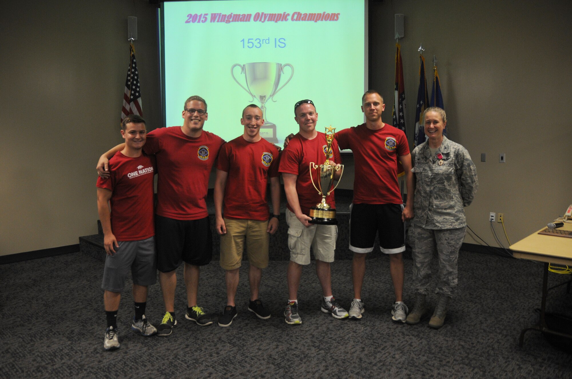 Col. Bobbi Doorenbos, 188th Wing commander, presents members of the 153rd Intelligence Squadron with the Wingman Olympics overall winner trophy June 7, 2015 at Ebbing Air National Guard Base, Fort Smith, Ark. The Wingman Olympics was held during Wingman Day and included a 1.5 mile run, volleyball, horseshoes, a mile relay, free-throw competition, golf pitching, a casting contest and a safety obstacle course. The 153rd IS attained 1st place by cumulatively scoring the most points in the Wingman Olympic events. (U.S. Air National Guard photo by Senior Airman Cody Martin/Released) 