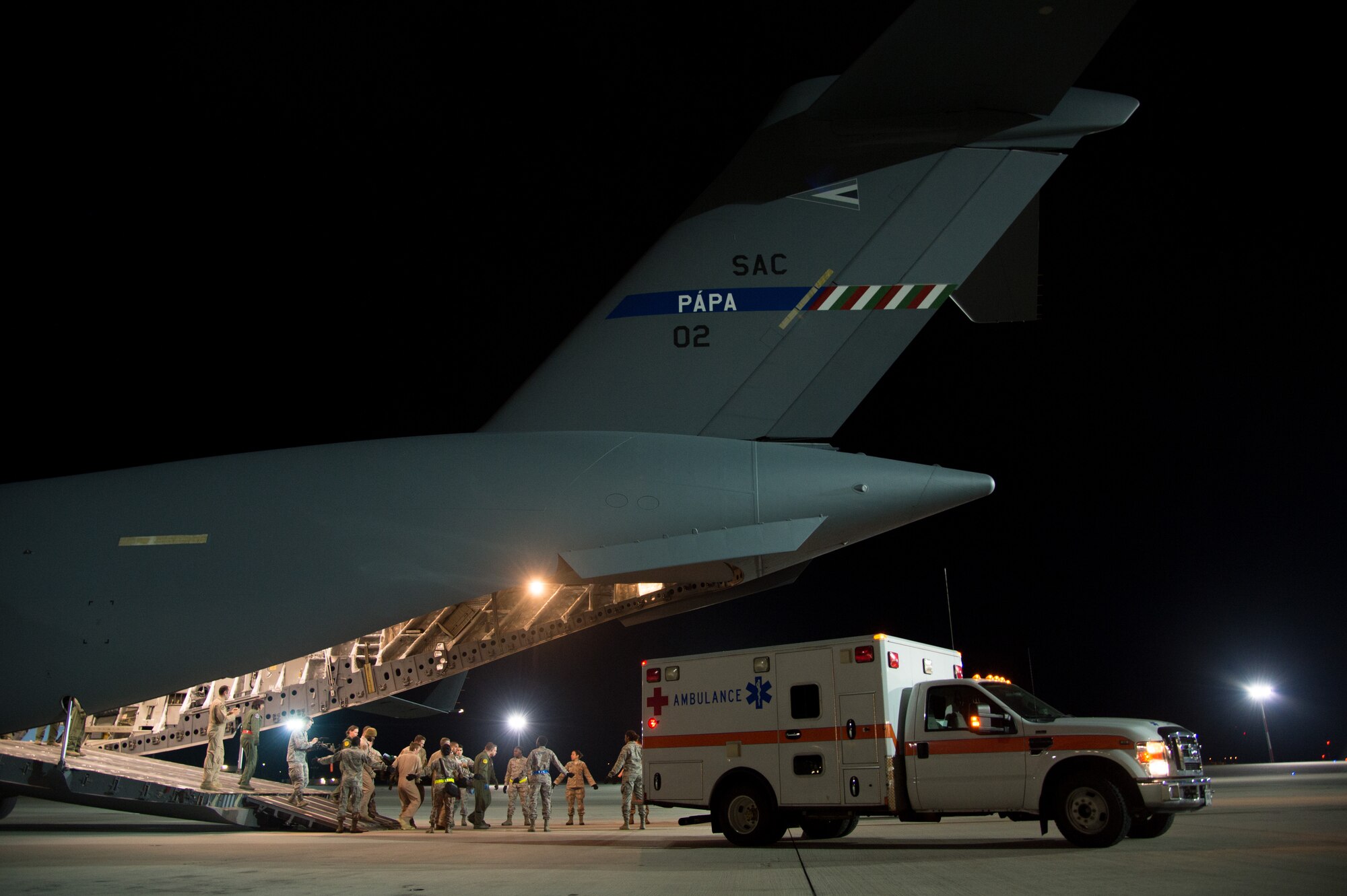 Patients are transferred into an ambulance where they will be transported to receive further medical care June 8, 2015, at Ramstein Air Base, Germany. Ramstein Airmen looked after the patients as they were being transported by military members from Strategic Airlift Capability Heavy Airlift Wing based at   Pápa Air Base, Hungary. This was the first time both bases joined together for a critical care aeromedical transport. (U.S. Air Force photo/Senior Airman Jonathan Stefanko)