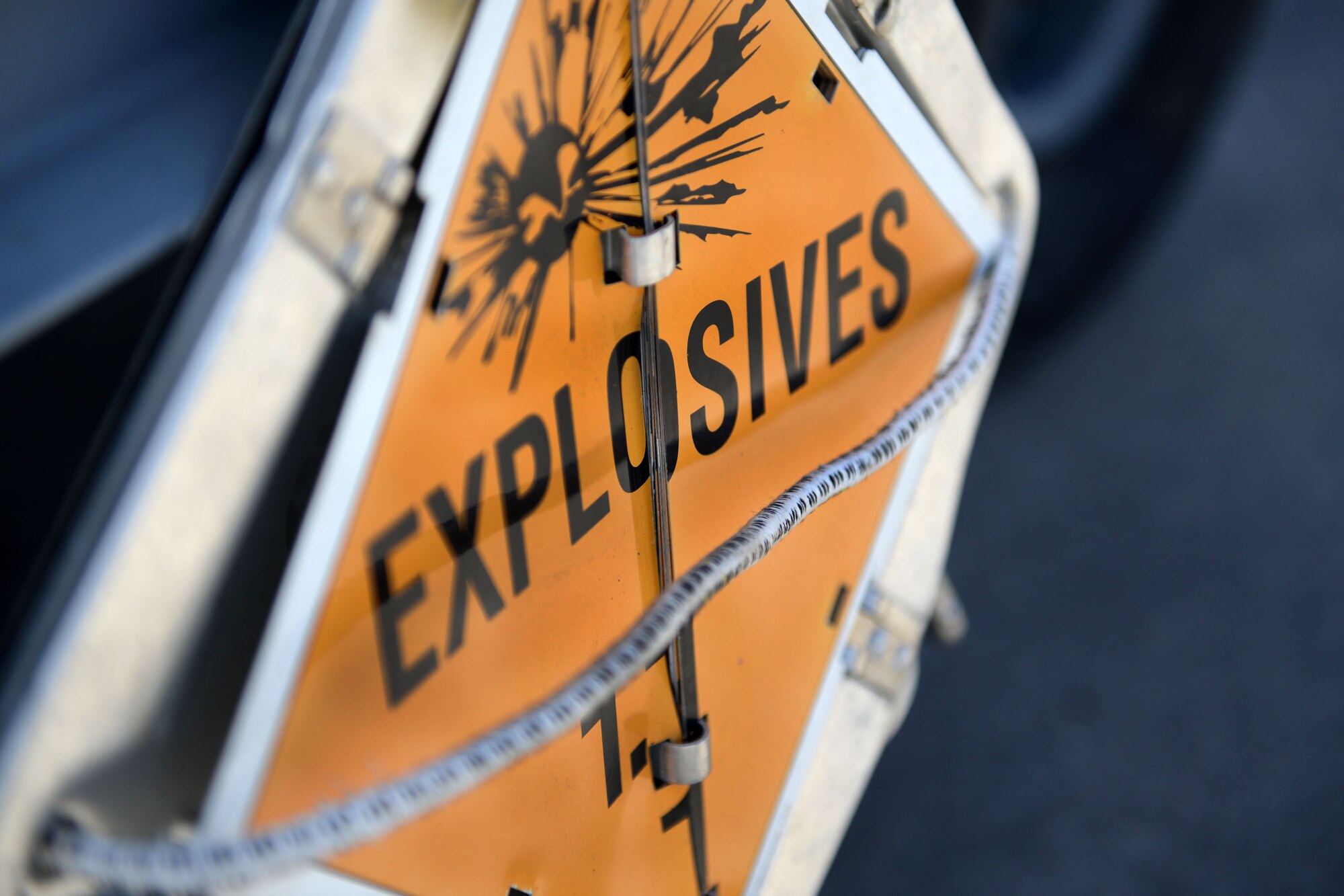 Airmen place 1.1D Mass Detonation explosives signs on trailers carrying munitions during the 2015 Combat Ammunition Production Exercise, Andersen Air Force Base, Guam, June 1, 2015. The signs notify people to maintain a safe distance from vehicles displaying the sign as they are used to alert the general public that they are explosive laden. (U.S. Air Force photo by Airman 1st Class Joshua Smoot/Released)