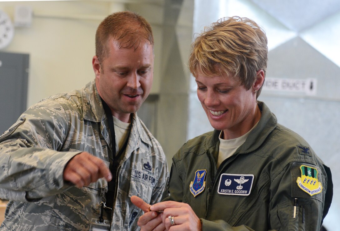 Master Sgt. William Huff, 2nd Maintenance Squadron deployed from Barksdale Air Force Base to the 36th Munitions Squadron, presents a coin to Col. Kristin Goodwin, 2nd Bomb Wing commander, June 3, 2015, at Andersen Air Force Base, Guam. Goodwin toured Andersen to meet with the units and Airmen in support of U.S. Pacific Command’s Continuous Bomber Presence mission. (U.S. Air Force photo by Airman 1st Class Arielle Vasquez/Released)