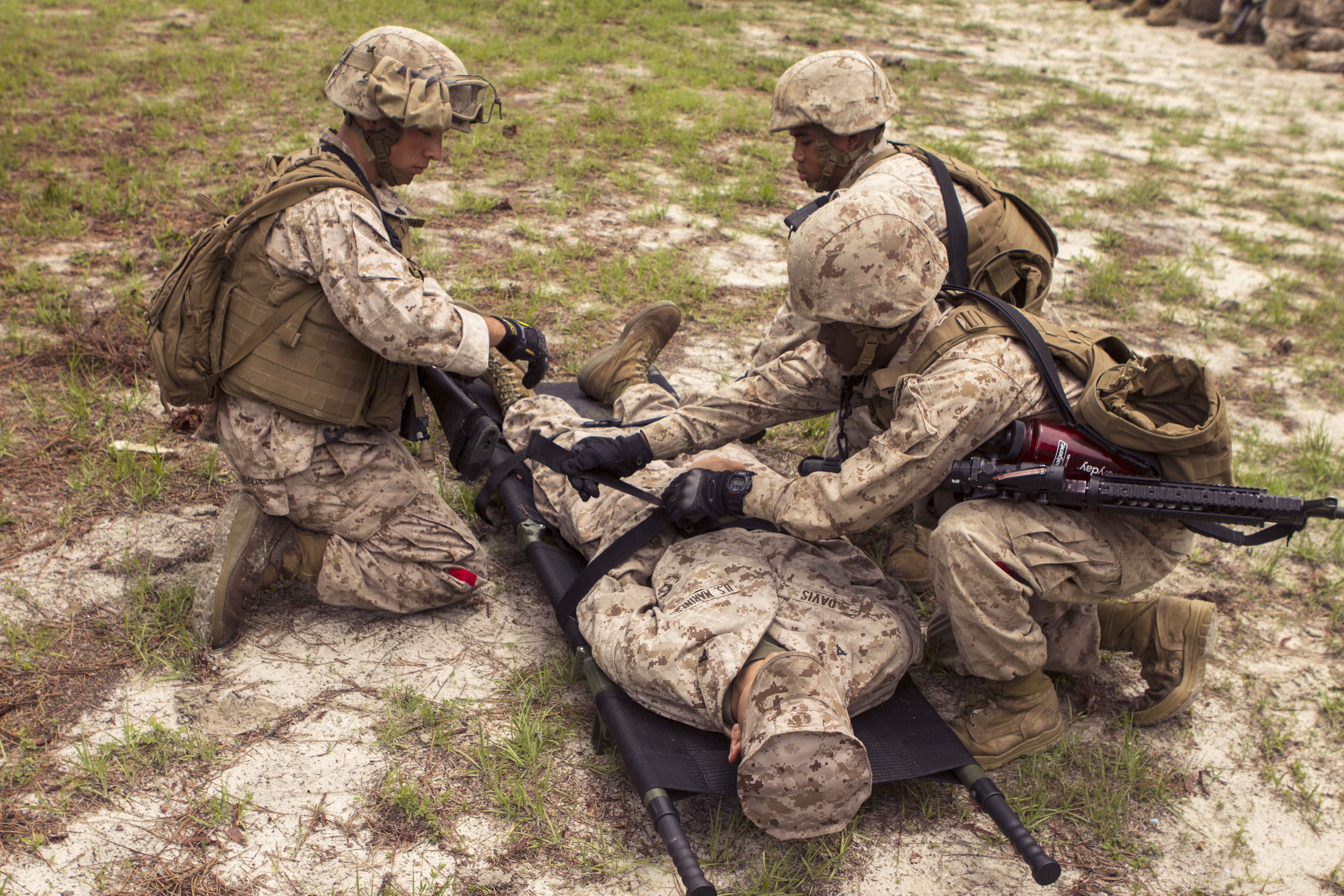 Marines strap a simulated casualty onto a litter during a mass casualty ...