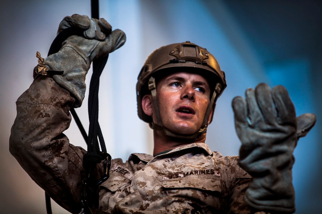 U.S. Marine Gunnery Sgt. Robert Turek demonstrates locking out while rappelling in the hangar bay of the USS Essex (LHD 2) in the East China Sea, June 2, 2015. Turek is a member of the 15th Marine Expeditionary Unit’s Maritime Raid Force. Locking out allows the Marines to stop descending in case they need to fix their gear or their landing area becomes unsafe. (U.S. Marine Corps photo by Cpl. Elize McKelvey/Released)