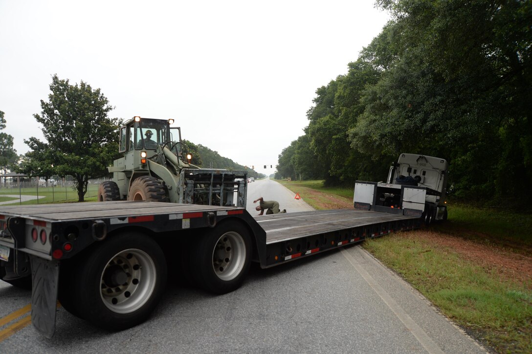 Sgt. Lester Williams, automotive mechanic, Marine Corps Logistics Command, ensures equipment is properly positioned in preparation to free a big rig from a muddy embankment on the side of the road near the Fleming Road truck gate.