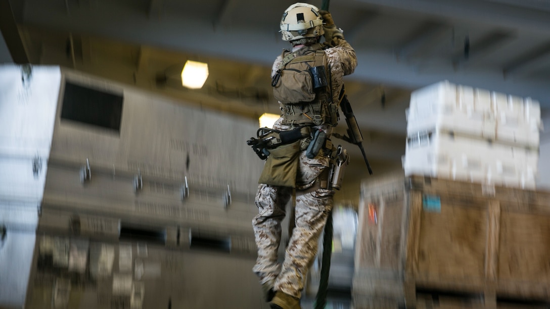 A U.S. Marine with the 15th Marine Expeditionary Unit’s Maritime Raid Force fast-ropes aboard the USS Essex (LHD 2) in the South China Sea, June 11, 2015. This technique gives the MRF the ability to quickly insert onto an objective whether they are landing on a ship or on top of a building. 