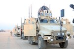 A line of mine resistant ambush protected vehicles operated by Soldiers with Company F, 3rd Battalion, 116th Cavalry Regiment, 3rd Sustainment Brigade, 103rd Sustainment Command (Expeditionary), stand ready to begin a convoy at Joint Base Balad, Iraq.