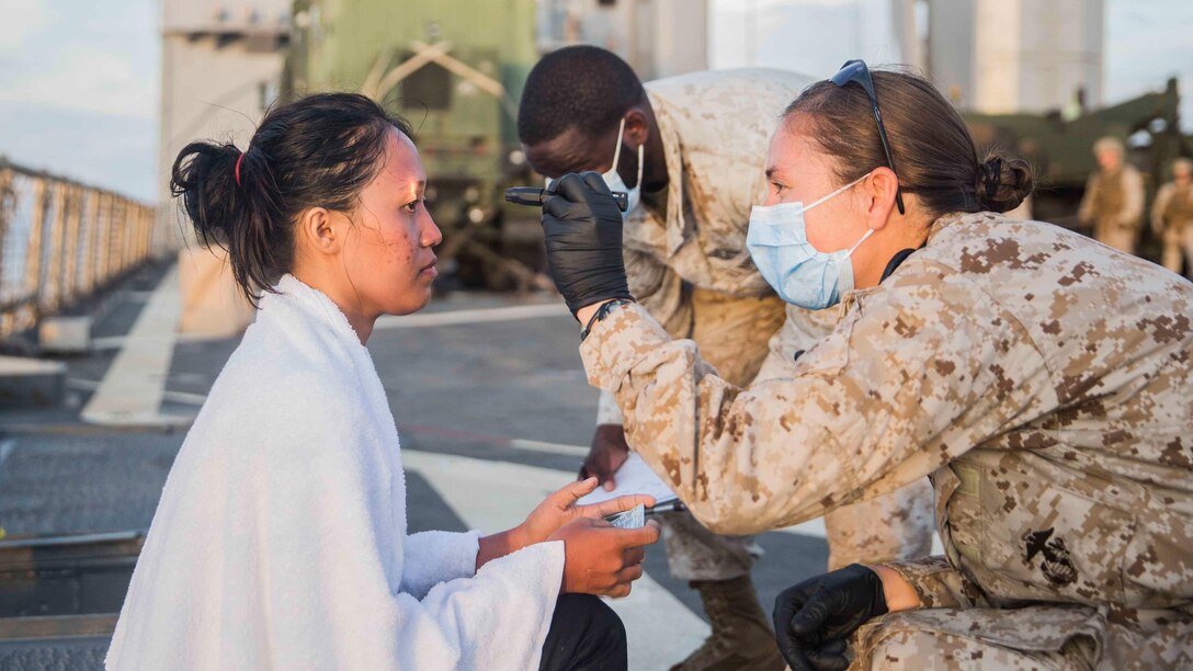 U.S. Navy corpsmen assigned to the 15th Marine Expeditionary Unit provide medical attention to a distressed mariner aboard the USS Rushmore (LSD 47) at sea in the Makassar Strait, June 10, 2015. Rushmore rendered assistance to the distressed mariners in the waters between the Indonesian islands of Kalimantan and Sulawesi. Once on board, evacuees were provided food and medical attention by Marines and sailors of the 15th Marine Expeditionary Unit and Essex Amphibious Ready Group.
