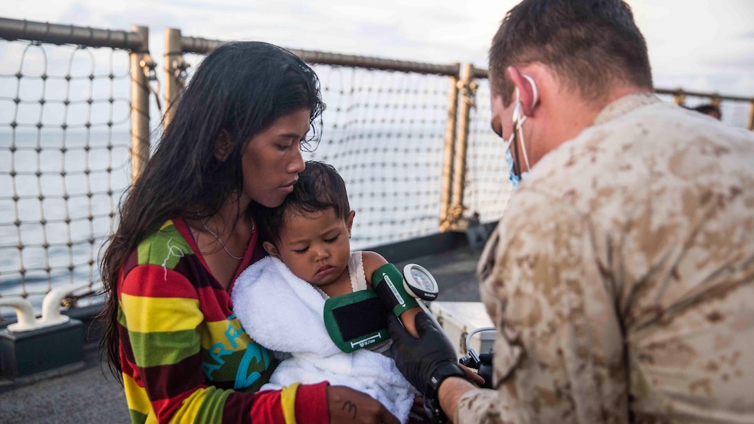 A U.S. Navy corpsman assigned to the 15th Marine Expeditionary Unit provides medical attention to a distressed mariner aboard the USS Rushmore (LSD 47) at sea in the Makassar Strait, June 10, 2015. Rushmore rendered assistance to the distressed mariners in the waters between the Indonesian islands of Kalimantan and Sulawesi. Once on board, evacuees were provided food and medical attention by Marines and sailors of the 15th Marine Expeditionary Unit and Essex Amphibious Ready Group. 