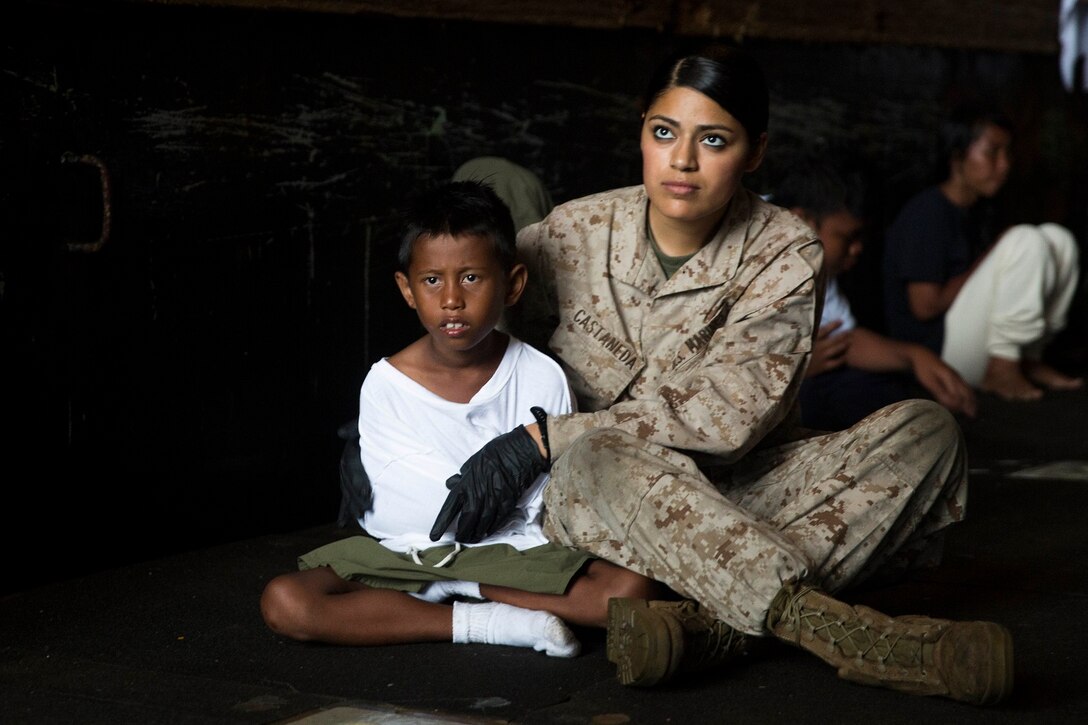 U.S. Marine Lance Cpl. Jasmine Castaneda comforts a distressed mariner aboard the USS Rushmore (LSD 47), after he was rescued from a sinking craft in the waters between the Indonesian islands of Kalimantan and Sulawesi, June 11, 2015. Castaneda is a supply warehouse clerk with Combat Logistics Battalion 15, 15th Marine Expeditionary Unit. Once on board, distressed mariners were provided food and medical attention by Marines and Sailors of the 15th MEU and Essex Amphibious Ready Group before being transferred to an Indonesian coast guard vessel. (U.S. Marine Corps photo by Sgt. Emmanuel Ramos/Released)