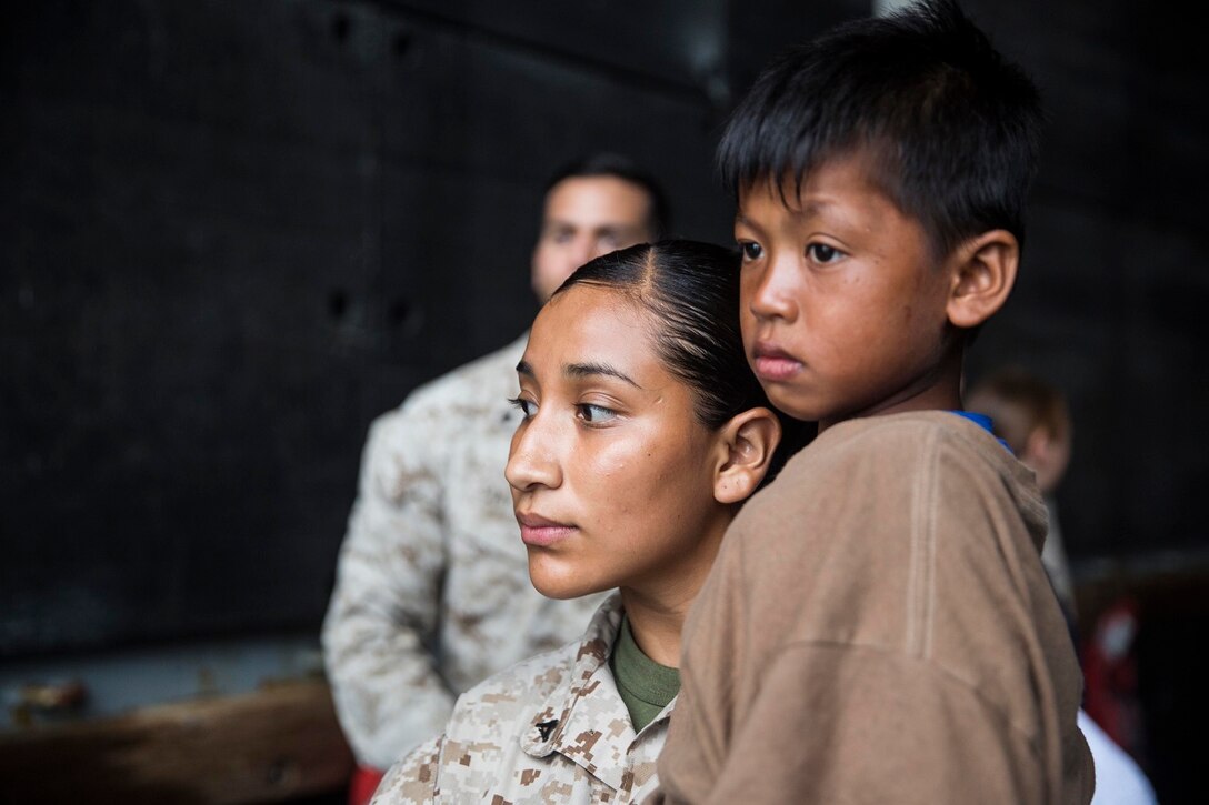 U.S. Marine Lance Cpl. Karina Navarro-Aguilera carries an Indonesia child as he waits to be transported to an Indonesian coast guard vessel from the USS Rushmore (LSD 47), June 11, 2015. Navarro-Aguilera is supply administrative clerk with Combat Logistics Battalion 15, 15th Marine Expeditionary Unit. The child, along with 64 other distressed mariners was rescued from a sinking craft in the Makassar Strait between the Indonesian islands of Kalimantan and Sulawesi. Once on board, the mariners were provided food and medical attention by Marines and Sailors of the 15th MEU and Essex Amphibious Ready Group. (U.S. Marine Corps photo by Sgt. Emmanuel Ramos/Released)
