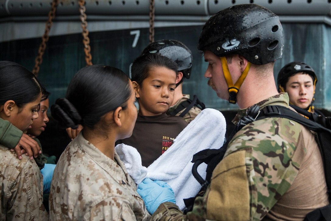 U.S. Marine Lance Cpl. Karina Navarro-Aguilera, left, hands off a distressed mariner to a Sailor from the USS Rushmore (LSD 47), June 11, 2015. Navarro-Aguilera is supply administrative clerk with Combat Logistics Battalion 15, 15th Marine Expeditionary Unit. The mariners were rescued from a sinking craft in the Makassary Strait. Once on board, the mariners were provided food and medical attention by Marines and Sailors of the 15th MEU and Essex Amphibious Ready Group. (U.S. Marine Corps photo by Sgt. Emmanuel Ramos/Released)