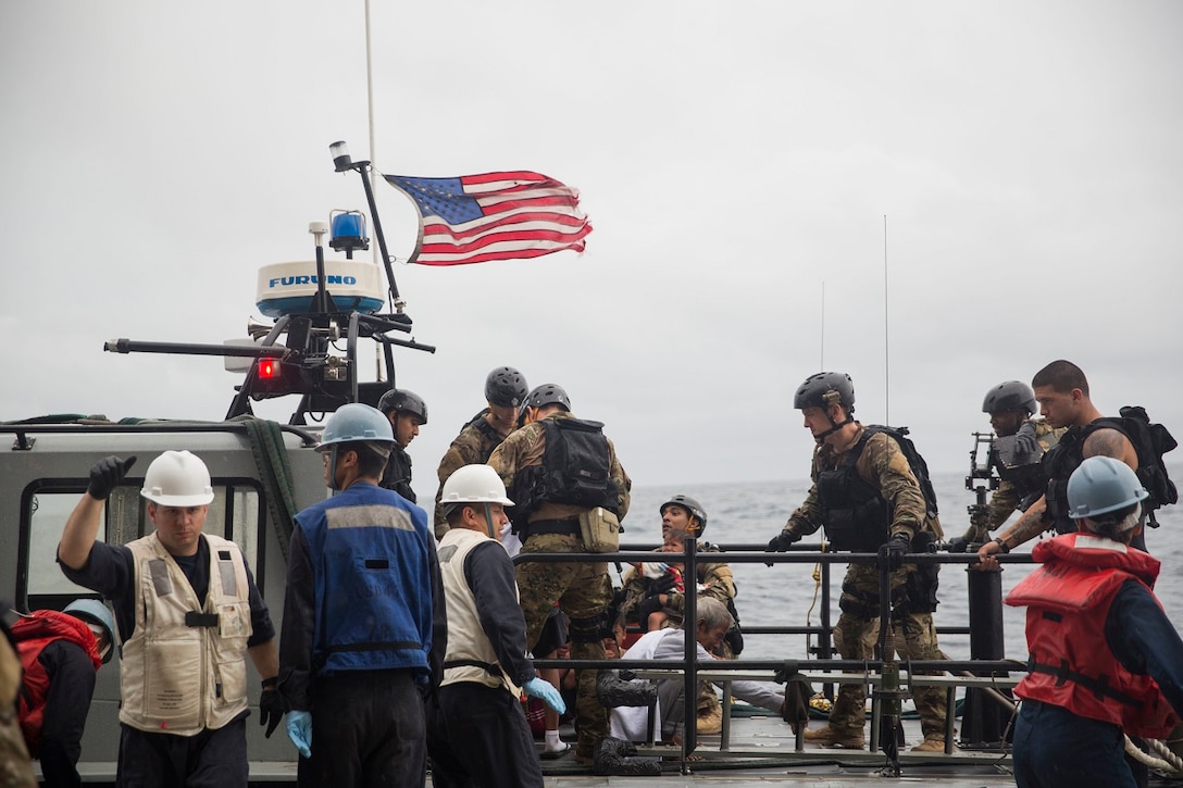 U.S. Marines and Sailors with the 15th Marine Expeditionary Unit and the Essex Amphibious Ready Group assist rescued mariners onto a watercraft to be transported to an Indonesian coast guard vessel from USS Rushmore (LSD 47) in the Pacific Ocean, June 11, 2015. Rushmore rendered assistance to the distressed mariners in the waters between the Indonesian islands of Kalimantan and Sulawesi while transiting the area during a deployment with the Essex ARG and 15th MEU. Once on board, distressed mariners were provided food and medical attention by Marines and Sailors of the 15th MEU and Essex ARG. (U.S. Marine Corps photo by Sgt. Emmanuel Ramos/Released)