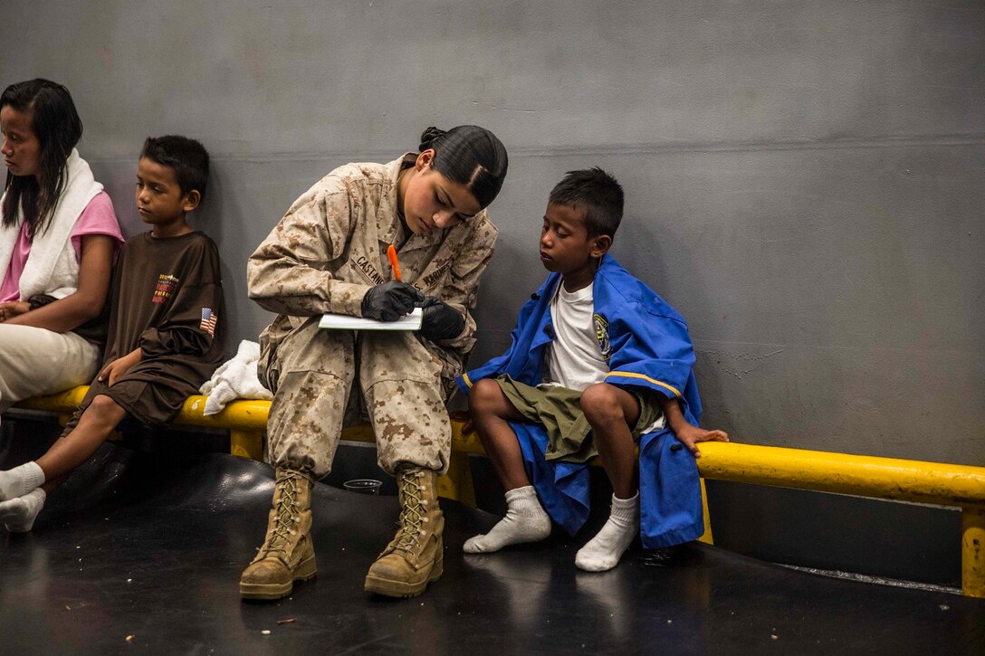 U.S. Marine Lance Cpl. Jasmine Castaneda comforts a distressed mariner aboard the USS Rushmore (LSD 47), after he was rescued from a sinking craft in the waters between the Indonesian islands of Kalimantan and Sulawesi, June 11, 2015. Castaneda is a supply warehouse clerk with Combat Logistics Battalion 15, 15th Marine Expeditionary Unit. Once on board, distressed mariners were provided food and medical attention by Marines and Sailors of the 15th MEU and Essex Amphibious Ready Group before being transferred to an Indonesian coast guard vessel. (U.S. Marine Corps photo by Sgt. Emmanuel Ramos/Released)