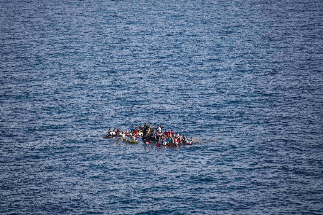 Distressed mariners wait to be rescued by U.S. Marines and Sailors with 15th Marine Expeditionary Unit and Essex Amphibious Ready Group aboard the USS Rushmore (LSD 47), at sea in the Makassar Strait, June 10, 2015. Sixty-five people were brought aboard Rushmore after it was discovered they were floating on bamboo rafts tied together with no means of propulsion. Once on board, evacuees were provided food and medical attention by Marines and sailors of the 15th Marine Expeditionary Unit and Essex Amphibious Ready Group. (U.S. Marine Corps photo by Sgt. Emmanuel Ramos/Released)