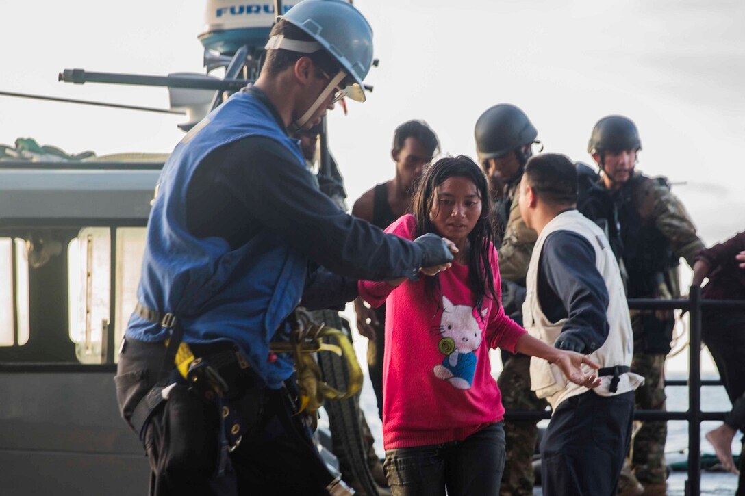 Sailors from the Essex Amphibious Ready Group help distressed mariners board the USS Rushmore (LSD 47) in the Makassar Strait, June 10, 2015. Rushmore rendered assistance to the distressed mariners in the waters between the Indonesian islands of Kalimantan and Sulawesi. Once on board, evacuees were provided food and medical attention by Marines and sailors of the 15th Marine Expeditionary Unit and Essex Amphibious Ready Group.(U.S. Marine Corps photo by Sgt. Emmanuel Ramos/Released)