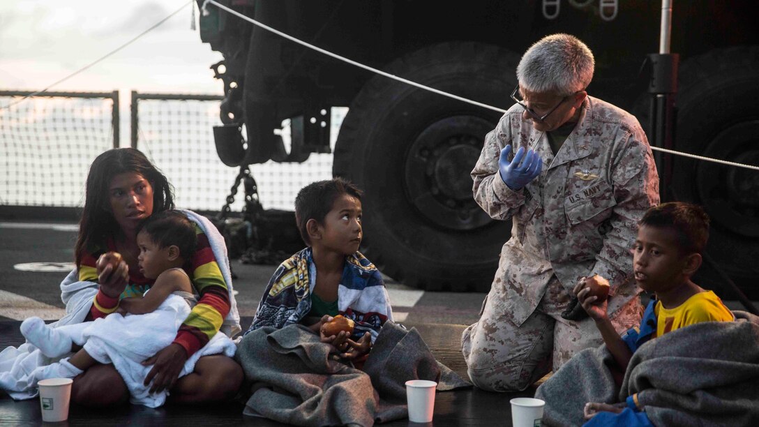 Navy Lt. Diane Hampton, the chaplain for Combat Logistics Battalion 15, 15th Marine Expeditionary Unit, comforts distressed mariners aboard the USS Rushmore (LSD 47) at sea in the Makassar Strait, June 10, 2015. Rushmore rendered assistance to the distressed mariners in the waters between the Indonesian islands of Kalimantan and Sulawesi. Once on board, the evacuees were provided food and medical attention by Marines and sailors of the 15th Marine Expeditionary Unit and Essex Amphibious Ready Group. 