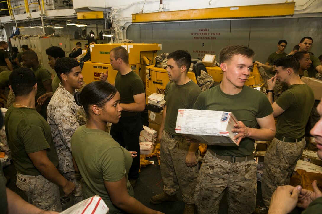 U.S. Marines with the 15th Marine Expeditionary Unit sort out packages aboard the USS Essex (LHD 2) in the South China Sea, June 10, 2015. Marines and Sailors aboard the USS Essex helped sort through hundreds of pieces of mail from friends and family members. (U.S. Marine Corps photo by Cpl. Anna Albrecht/Released)