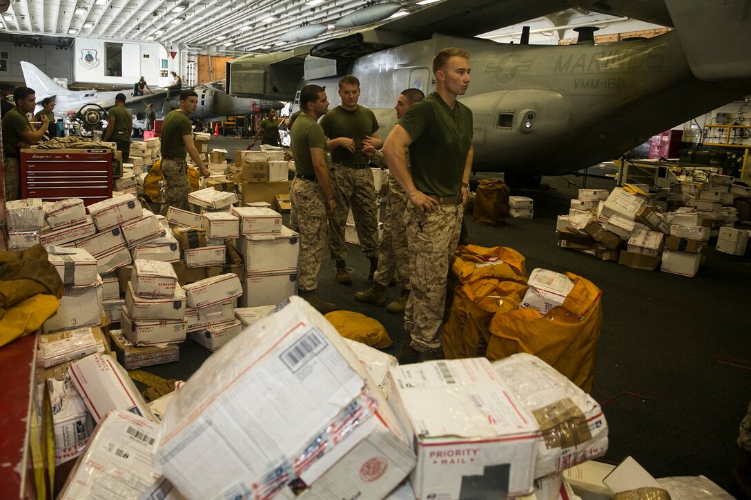 U.S. Marines with the 15th Marine Expeditionary Unit sort through mail aboard the USS Essex (LHD 2) in the South China Sea, June 10, 2015. Marines and Sailors aboard the USS Essex helped sort through hundreds of pieces of mail from friends and family members. (U.S. Marine Corps photo by Cpl. Anna Albrecht/Released)