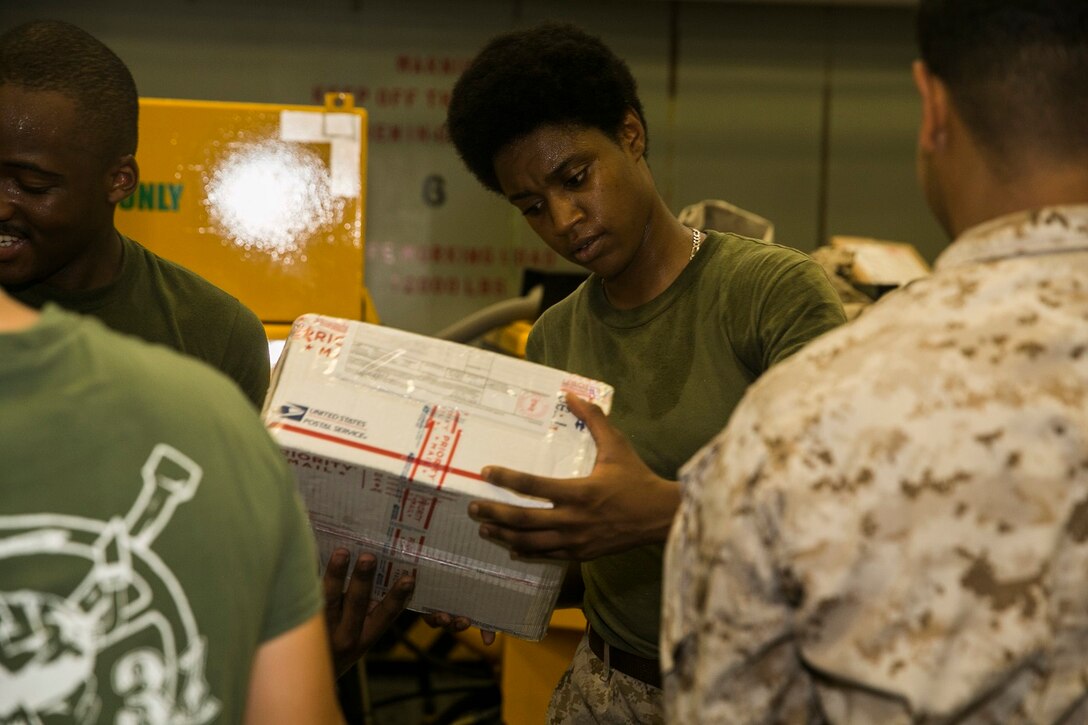 U.S. Marine Sgt. Shadaine Longmore helps sort mail aboard the USS Essex (LHD 2) in the South China Sea, June 10, 2015. Longmore is a supply warehouse clerk with the 15th Marine Expeditionary Unit’s Command Element. Marines and Sailors aboard the USS Essex helped sort through hundreds of pieces of mail from friends and family members. (U.S. Marine Corps photo by Cpl. Anna Albrecht/Released)