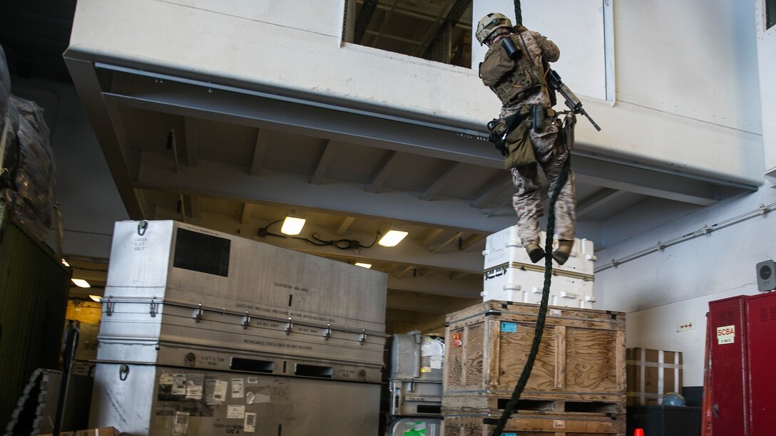 A U.S. Marine with the 15th Marine Expeditionary Unit’s Maritime Raid Force fast-ropes aboard the USS Essex (LHD 2) in the South China Sea, June 11, 2015. This technique gives the MRF the ability to quickly insert onto an objective, whether they are landing on a ship or on top of a building. 
