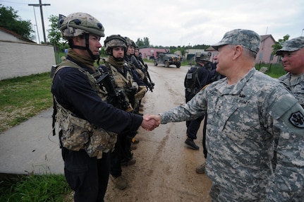 Army Gen. Frank Grass, chief, National Guard Bureau, and Air Force Chief Master Sgt. Mitchell Brush, senior enlisted advisor to the chief, greet Latvian soldiers embedded with Michigan National Guard members acting as opposing forces for active duty troops exercising at Joint Multinational Readiness Center -- Hohenfels, Germany, May 30, 2015. Michigan and Latvia are paired in the National Guard State Partnership Program. 