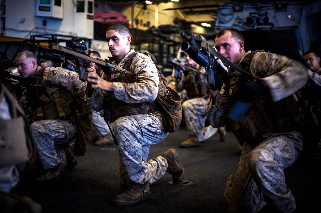 U.S. Marines with Light Armored Reconnaissance Detachment, Battalion Landing Team 3rd Battalion, 1st Marine Regiment, 15th Marine Expeditionary Unit, take a knee to perform a tactical-reload drill with their rifles in the hangar bay of the USS Essex (LHD 2) in the East China Sea, June 3, 2015. The Marines with LAR Detachment continue to refine their skills during their seven-month deployment. (U.S. Marine Corps photo by Cpl. Elize McKelvey/Released)