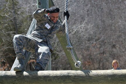 Senior Airman Jasson Archila from the 143rd Logistic Readiness Squadron, Rhode Island National Guard swings up and over an obstacle during the 7th Annual Obstacle Course Challenge for Sexual Assault Awareness Month at Camp Fogarty, April 12, 2015.