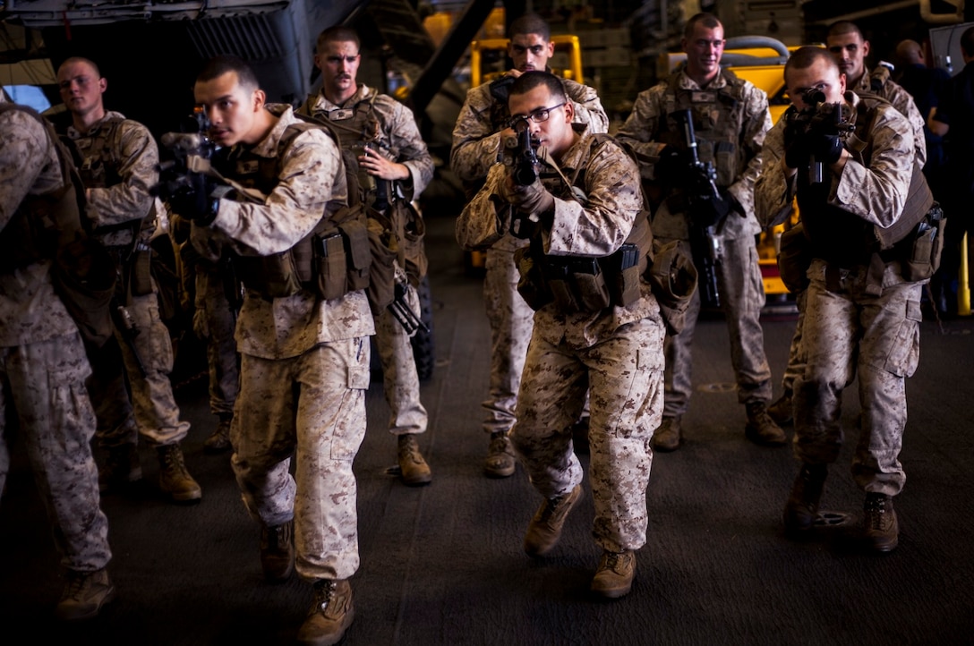 U.S. Marines with Light Armored Reconnaissance Detachment, Battalion Landing Team 3rd Battalion, 1st Marine Regiment, 15th Marine Expeditionary Unit, advance while waiting for the call to perform a speed-reload drill in the hangar bay of the USS Essex (LHD 2) in the East China Sea, June 3, 2015. The Marines with LAR Detachment continue to refine their skills during their seven-month deployment. (U.S. Marine Corps photo by Cpl. Elize McKelvey/Released)