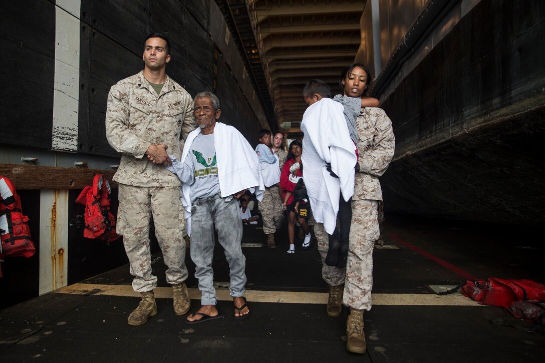 U.S. Marines with the 15th Marine Expeditionary Unit assist distressed mariners ready to be transported to an Indonesian coast guard vessel from the USS Rushmore (LSD 47), June 11, 2015. The distressed mariners were rescued from a sinking craft in the Makassar Strait. Once on board, the mariners were provided food and medical attention by Marines and Sailors of the 15th MEU and Essex Amphibious Ready Group. (U.S. Marine Corps photo by Sgt. Emmanuel Ramos/Released)
