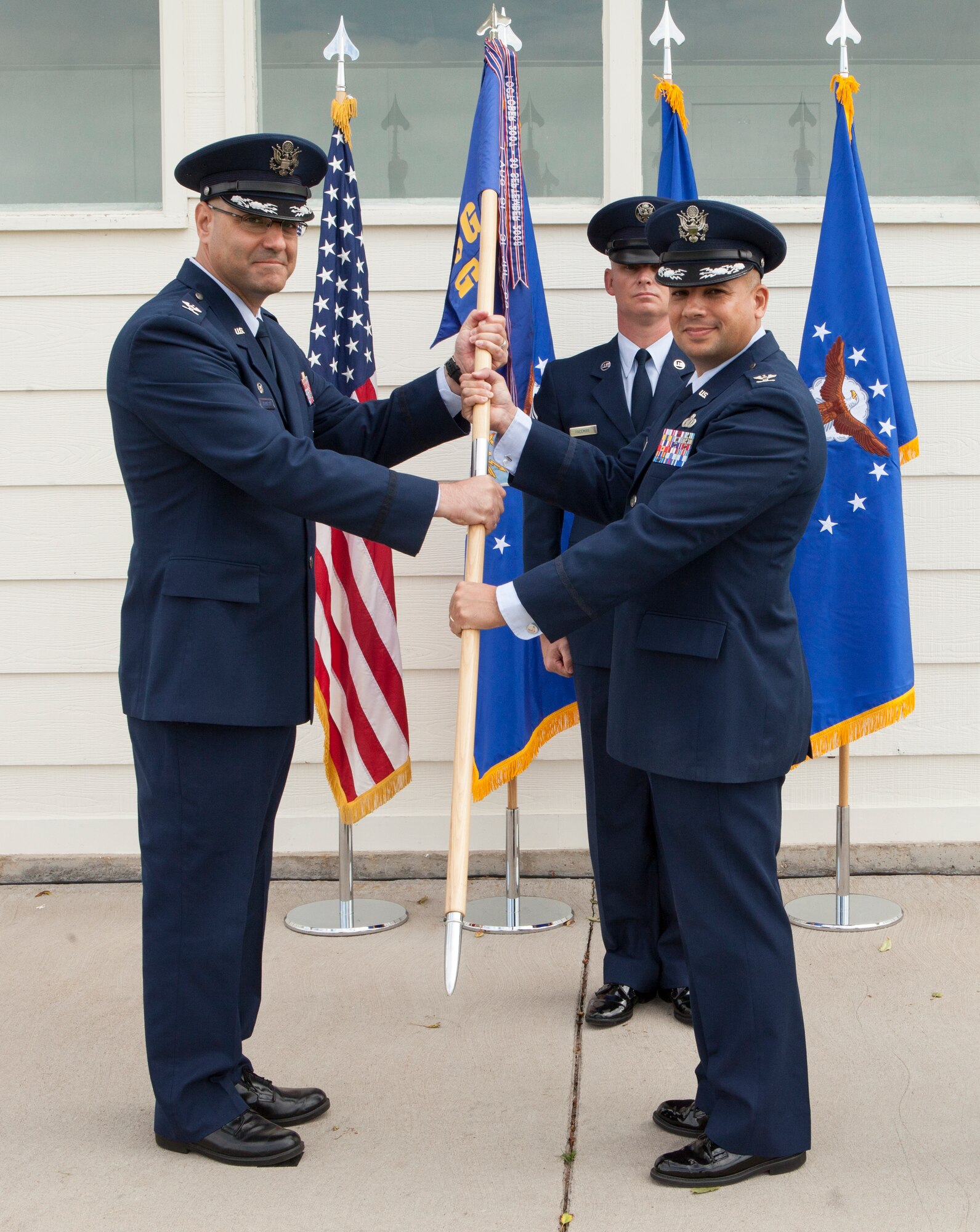 Col. Stephen M. Kravitsky, 90th Missile Wing commander, passes the 90th Mission Support Group guidon to Col. Frank R. Verdugo as Verdugo assumes command of the group during a change-of-command ceremony on Argonne Parade Field, F.E. Warren Air Force Base, Wyo., June 11, 2015. The passing of the guidon symbolized the transfer of authority and responsibility from Col Travis E. Condon to Verdugo. 
