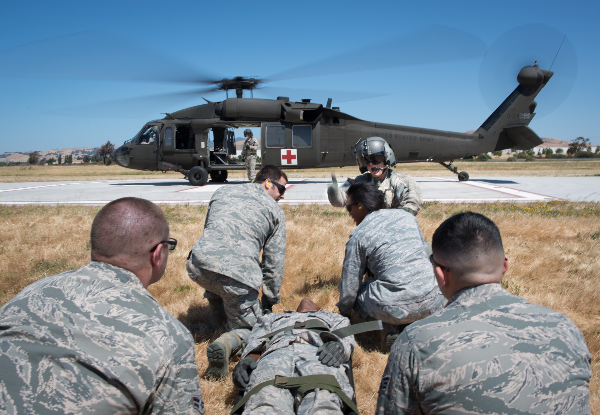 Medical technicians from the 349th Medical Group prepare to carry a litter with a simulated earthquake victim to a UH-60 Black Hawk helicopter June 6, 2015, at Travis Air Force Base, California, during an exercise. (U.S. Air Force photo by Ken Wright/Released)
