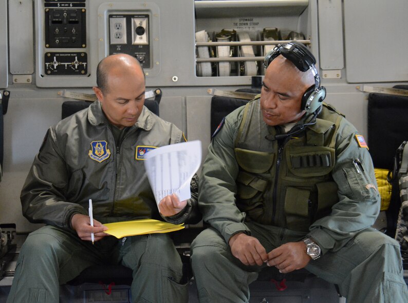 Senior Master Sgt. Arnulfo Tumbaga (Left), 349th Security Forces Squadron superintendent of plans and programs, and Staff Sgt. Juan Perez (Right), 349th SFS Phoenix Raven, discuss security concerns during the 349th Air Mobility Wing’s Air Force Specialty Code Training Weekend June 6 in the back of a C-17 Globemaster III at Travis Air Force Base, Calif. The AFSC Training Weekend from June 6 - 7, 2015, centered around the wing's ability to respond to a major earthquake in northern California, while working in concert with other military, federal and state agencies to provide relief and support where needed. (U.S. Air Force photo/Tech. Sgt. James Hodgman)