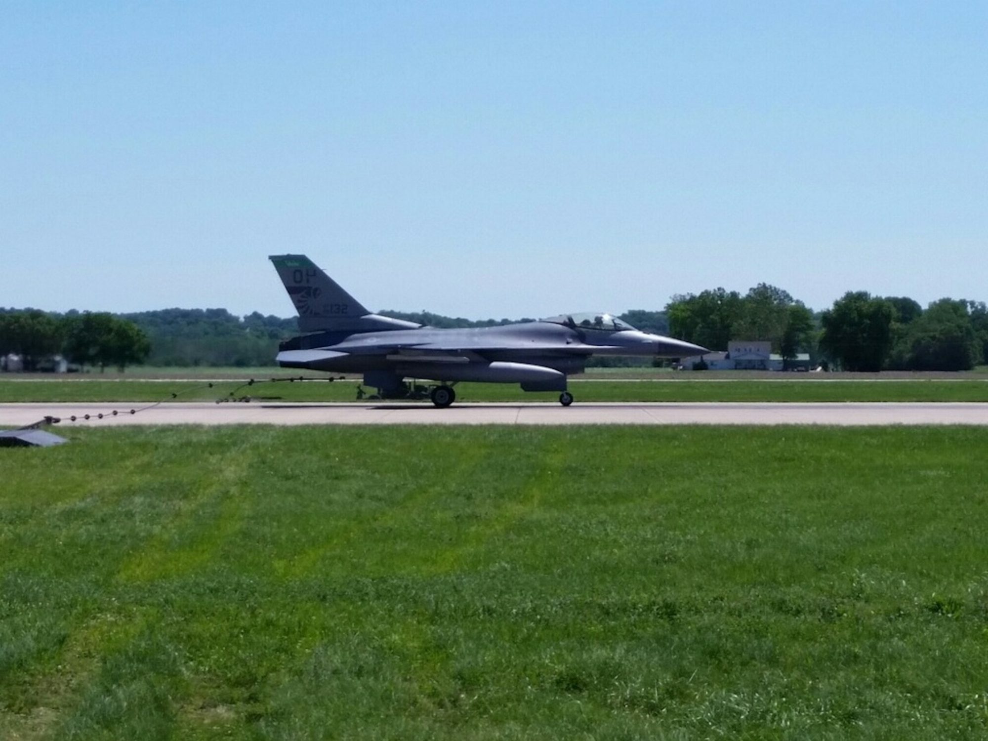 An F-16 Fighting Falcon from the 180th Fighter Wing, Ohio Air National Guard, sits on the runway at Rosecrans Air National Guard Base, St. Joseph, Mo., June 8, 2015. The aircraft was used to test and certify the use of a mobile aircraft arresting system, or MAAS, on the runway. The temporary MAAS will be deployed at Rosecrans during the Wings Over Whiteman Airshow at Whiteman Air Force Base as a backup for the U.S. Air Force Thunderbirds if they need to make an emergency arrestment landing. (U.S. Air Force photo by Staff Sgt. Alexander Toro)
