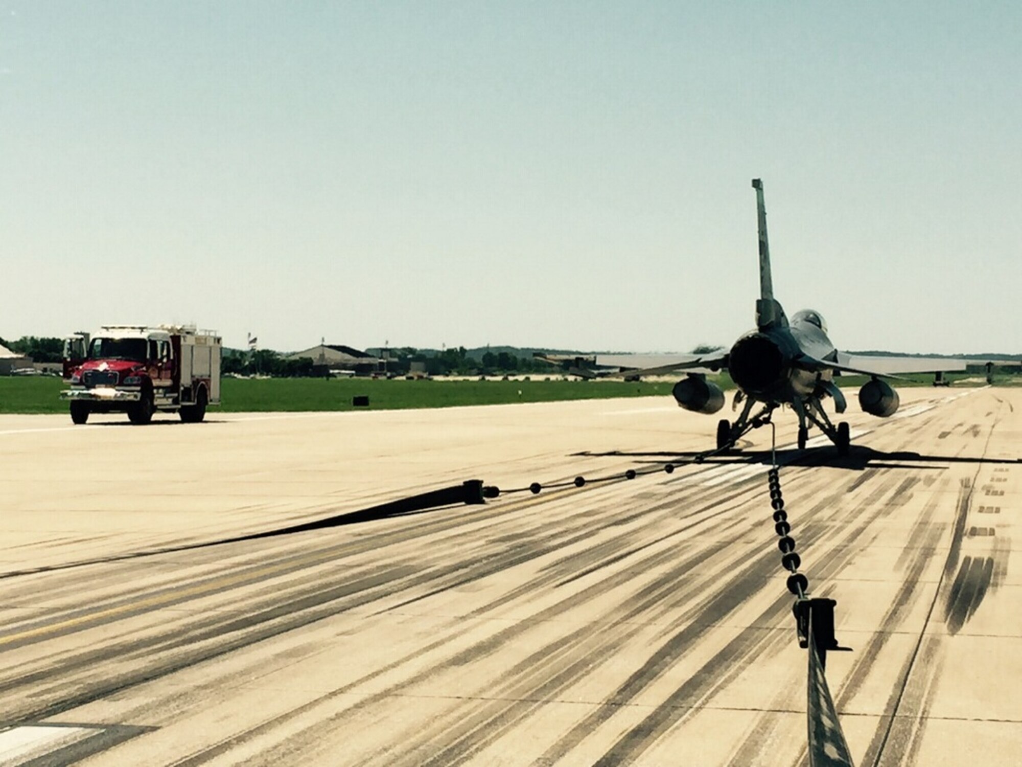 An F-16 Fighting Falcon from the 180th Fighter Wing, Ohio Air National Guard, sits on the runway at Rosecrans Air National Guard Base, St. Joseph, Mo., June 8, 2015. The aircraft was used to test and certify the use of a mobile aircraft arresting system, or MAAS, on the runway. The MAAS will be deployed at Rosecrans during the Wings Over Whiteman Airshow at Whiteman Air Force Base as a backup for the U.S. Air Force Thunderbirds should they need maintenance before or after the air show. (U.S. Air Force photo by Senior Airman Charles Puengpan)