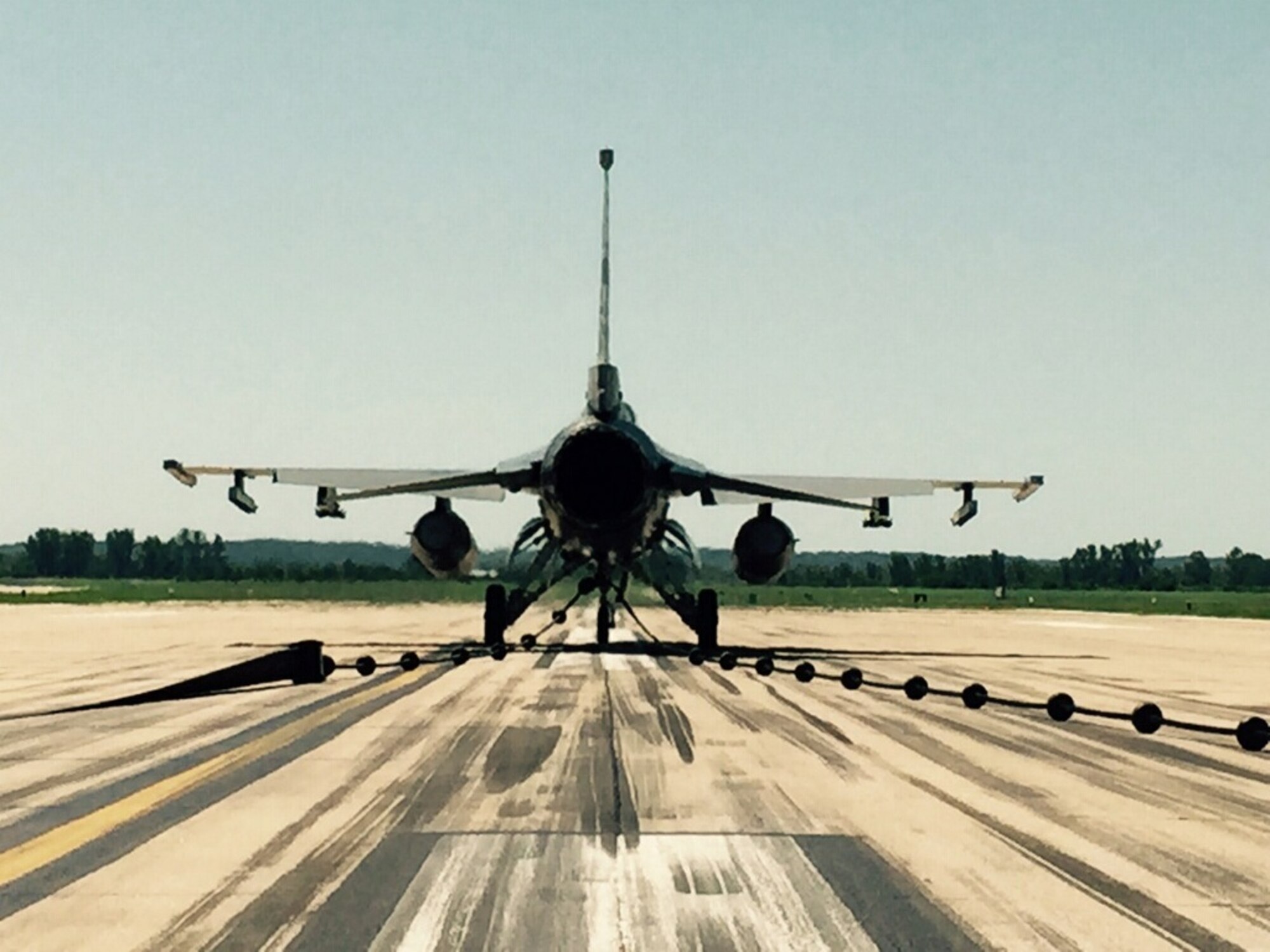 An F-16 Fighting Falcon from the 180th Fighter Wing, Ohio Air National Guard, sits on the runway at Rosecrans Air National Guard Base, St. Joseph, Mo., June 8, 2015. The aircraft was used to test and certify the use of a mobile aircraft arresting system, or MAAS, on the runway. The temporary MAAS will be deployed at Rosecrans during the Wings Over Whiteman Airshow at Whiteman Air Force Base as a backup for the U.S. Air Force Thunderbirds if they need to make an emergency arrestment landing. (U.S. Air Force photo by Senior Airman Charles Puengpan)