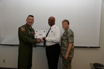 Robert Thomas, center, 47th Logistics Readiness Flight logistics manager, poses with Col. Brian Hastings, 47th Flying Training Wing commander, and Chief Master Sgt. Teresa Clapper, 47th FTW command chief, after accepting the XLer of the Week award here June 10, 2015. The XLer is a weekly award chosen by wing leadership and is presented to those who consistently make outstanding contributions to their unit and Laughlin. (U.S. Air Force photo by Airman 1st Class Brandon May )