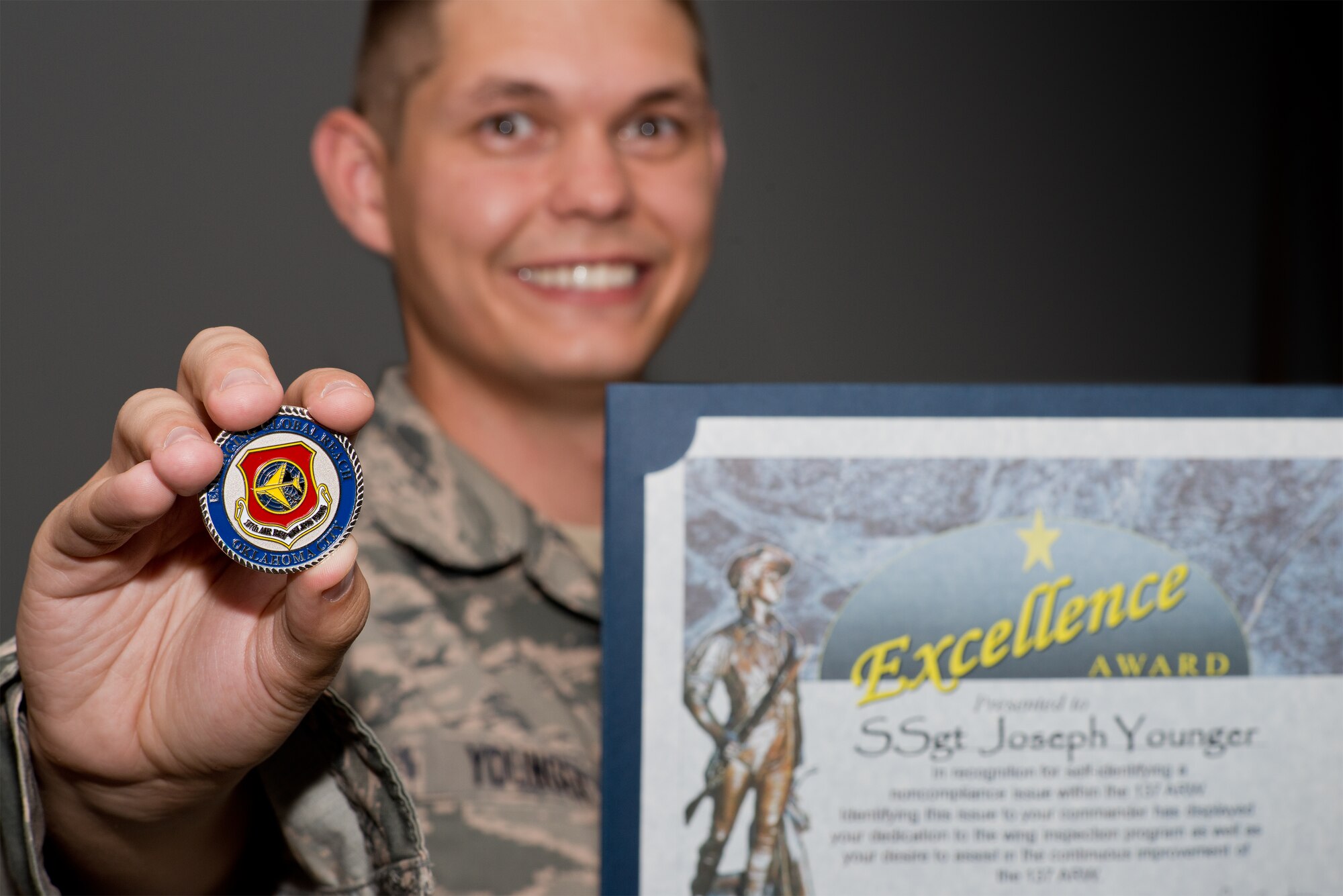 Staff Sgt. Joseph Younger, a member of the 137th Logistics Readiness Squadron, holds his Excellence Award, which he received after he reported an operations security issue, June 3, 2015.