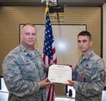 U.S. Air Force Master Sgt. Michael Murphy, 822d Base Defense Squadron operations superintendent, receives a Bronze Star Medal certificate from Col. Michael Ross, 820th Base Defense Group commander, during an awards ceremony June 10, 2015, at Moody Air Force Base, Ga. Murphy was awarded for his heroism in a combat zone in support of Operation Enduring Freedom. (U.S. Air Force photo by Airman Greg Nash/Released)