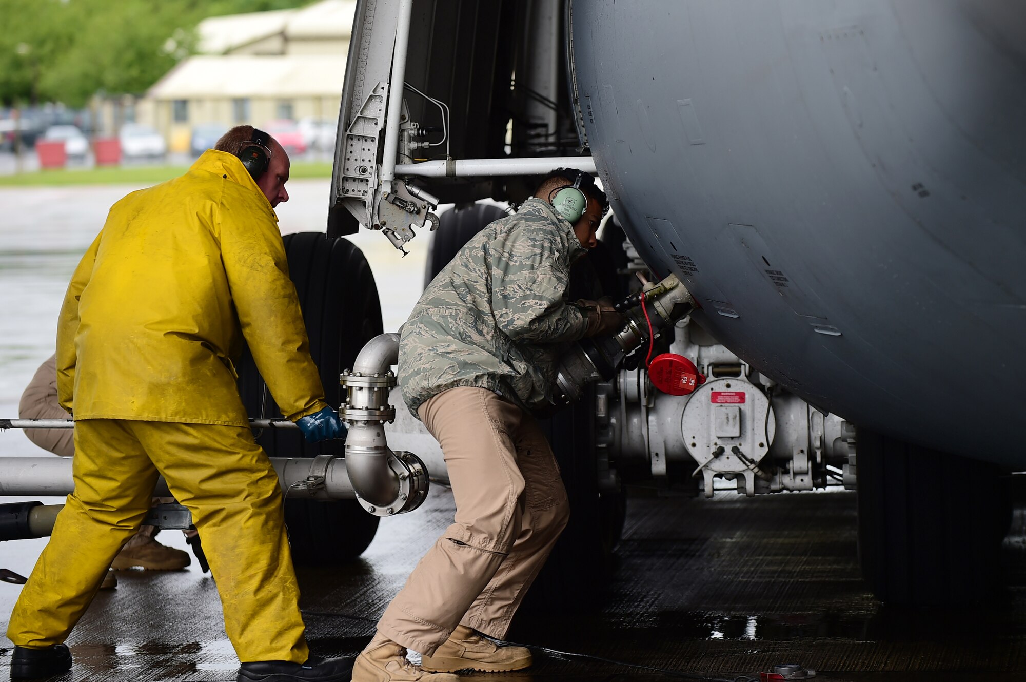 Gerald Leydon, 420th Air Base Squadron, fuel tech contractor, assists a C-5 crew chief from Dover Air Force Base Del., after landing on RAF Fairford, United Kingdom, June 2, 2015. The C-5 Super Galaxy landed on RAF Fairford in support of U.S. European Command Exercises BALTOPS 15 and SABER STRIKE 15 from June 5-21, 2015. (U.S. Air Force photo by Tech. Sgt. Chrissy Best)
